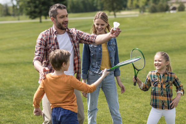 family playing badminton outside